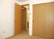 Thumbnail 6 of 13 - A room with a brown door and a white wall.