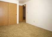 Thumbnail 5 of 13 - A room with a carpeted floor and two wooden doors.