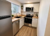 Thumbnail 2 of 16 - A modern kitchen with stainless steel appliances and wooden flooring.