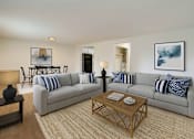 Thumbnail 1 of 17 - A living room with a grey couch and a coffee table.
