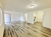 Thumbnail 9 of 17 - A room with wooden flooring and white walls.