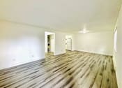 Thumbnail 10 of 17 - A room with wooden flooring and white walls.