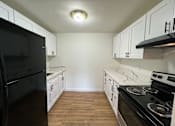 Thumbnail 13 of 17 - A kitchen with black appliances and white cabinets.