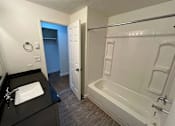 Thumbnail 8 of 17 - A bathroom with a sink, bathtub, and shower.