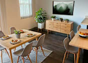 Thumbnail 5 of 27 - A dining room with a wooden table and chairs.