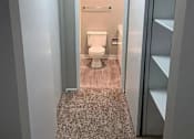 Thumbnail 12 of 13 - A bathroom with a toilet and a shelf.