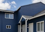 Thumbnail 11 of 11 - A blue house with a white door and windows.