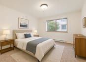 Thumbnail 8 of 14 - A bedroom with a bed, nightstand, and window.