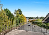 Thumbnail 2 of 14 - A metal fence with a gate leads to a parking lot.