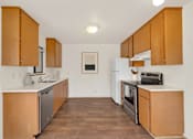 Thumbnail 4 of 14 - A kitchen with wooden cabinets and a white fridge.