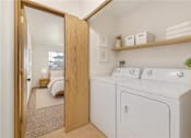 Thumbnail 5 of 14 - A small laundry room with a washer and dryer.