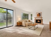Thumbnail 1 of 14 - A living room with a fireplace and sliding glass doors.