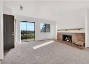 Thumbnail 7 of 14 - A room with a fireplace and a sliding glass door.
