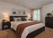 Thumbnail 2 of 18 - A bedroom with a large bed and a window with curtains.