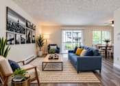 Thumbnail 6 of 18 - A living room with a blue couch and a coffee table.
