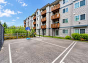 Thumbnail 13 of 18 - A parking lot in front of a residential building.
