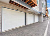 Thumbnail 16 of 18 - A row of white garage doors in front of a building.