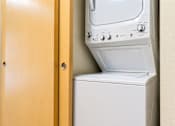 Thumbnail 10 of 18 - A white washing machine is in a wooden cabinet.