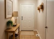 Thumbnail 9 of 18 - A hallway with a white door and a light hanging from the ceiling.