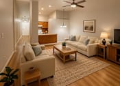 Thumbnail 14 of 18 - A living room with a couch, a chair, a coffee table, and a ceiling fan.