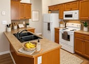 Thumbnail 15 of 18 - A kitchen with wooden cabinets and a white refrigerator.