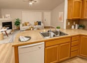Thumbnail 4 of 18 - A kitchen with wooden cabinets and a white dishwasher.