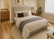 Thumbnail 1 of 18 - A bedroom with a bed, a mirror, and two framed pictures on the wall.