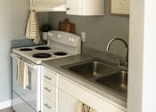 Thumbnail 3 of 20 - A kitchen with a white oven and sink.