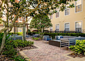 Thumbnail 36 of 42 - a courtyard with couches and chairs in front of an apartment building