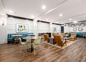 Thumbnail 23 of 42 - a seating area with tables and chairs in a lobby