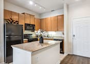 Thumbnail 7 of 42 - A kitchen with a black refrigerator and white cabinets.
