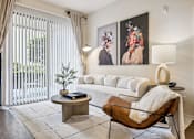 Thumbnail 10 of 42 - A living room with a white couch, a brown leather chair, and two paintings on the wall.
