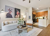 Thumbnail 8 of 42 - A living room with a white couch, a coffee table, and two abstract paintings on the wall.