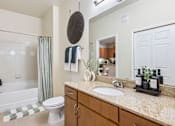 Thumbnail 16 of 42 - A bathroom with a white toilet, a sink, and a bathtub.