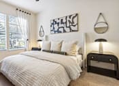 Thumbnail 11 of 42 - A bedroom with a large bed and a painting on the wall.