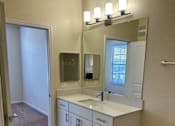 Thumbnail 18 of 47 - A bathroom with a toilet, sink, and mirror.