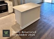 Thumbnail 22 of 47 - A newly renovated kitchen with a white island in the middle.