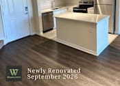 Thumbnail 19 of 47 - A newly renovated kitchen with a white island and stainless steel appliances.