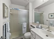 Thumbnail 7 of 16 - A bathroom with a toilet, sink, and shower.
