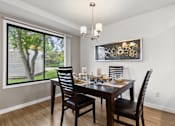 Thumbnail 4 of 15 - A dining room with a table set for two and a chandelier.
