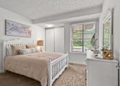 Thumbnail 10 of 15 - A bedroom with a large bed and a window with blinds.