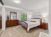 Thumbnail 8 of 15 - A bedroom with a large bed, a dresser, and a nightstand.