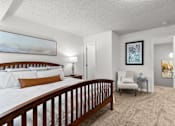 Thumbnail 9 of 15 - A bedroom with a large bed and a chair in it.