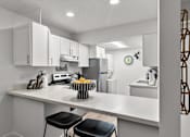 Thumbnail 7 of 12 - A kitchen with white cabinets and a white countertop.