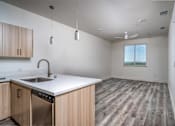 Thumbnail 6 of 16 - A kitchen with wooden cabinets and a stainless steel dishwasher.
