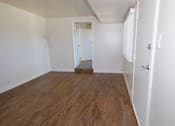 Thumbnail 3 of 20 - A room with wooden floors and white walls.