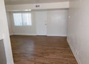 Thumbnail 13 of 20 - A room with wooden floors and white walls.
