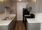 Thumbnail 2 of 20 - A kitchen with a black refrigerator and stove.