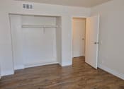 Thumbnail 11 of 20 - A room with a white door and a white closet with a white shelf.