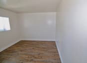 Thumbnail 9 of 20 - A room with wooden flooring and white walls.